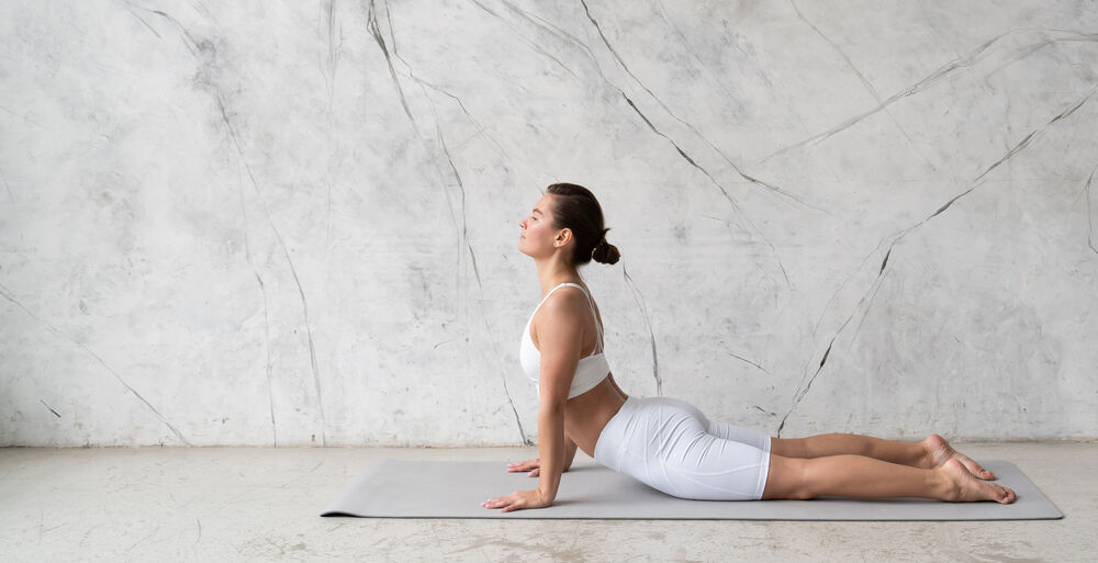 Mulher praticando yoga na posição cobra