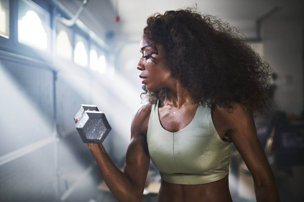 mulher negra treinando biceps
