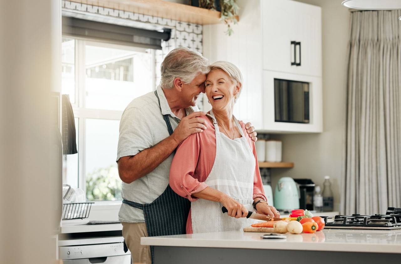 casal de idosos felizes cozinhando