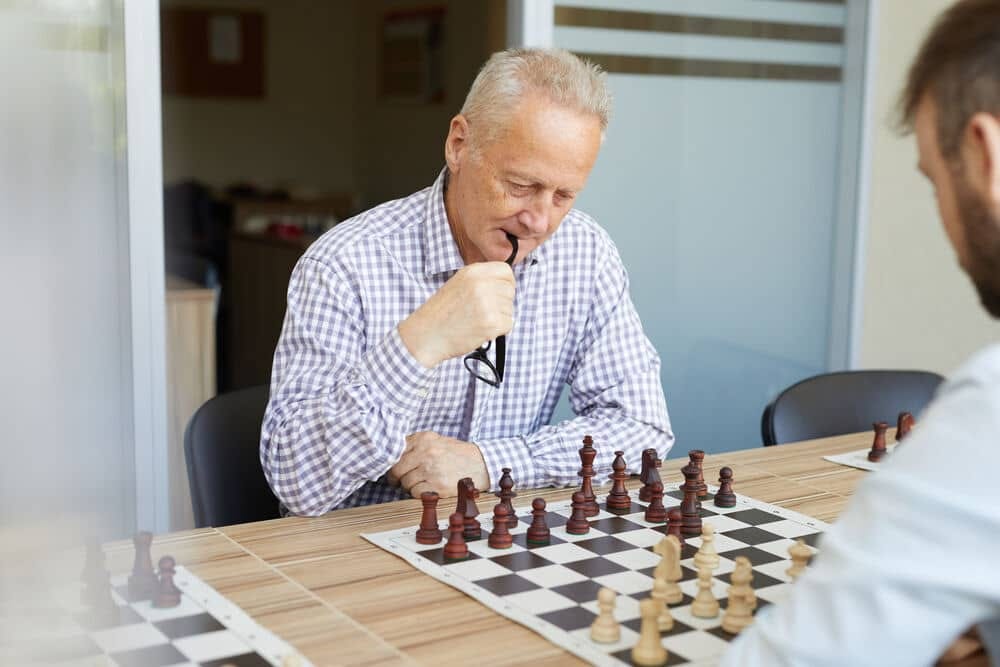 idoso jogando xadrez com o filho