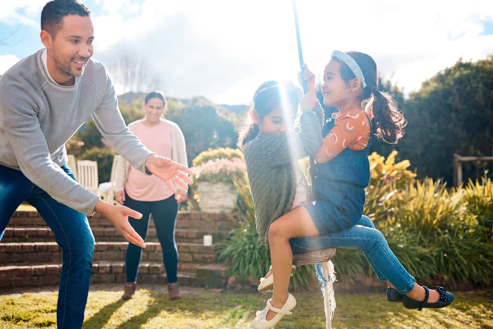 Família brincando de balanço no parque