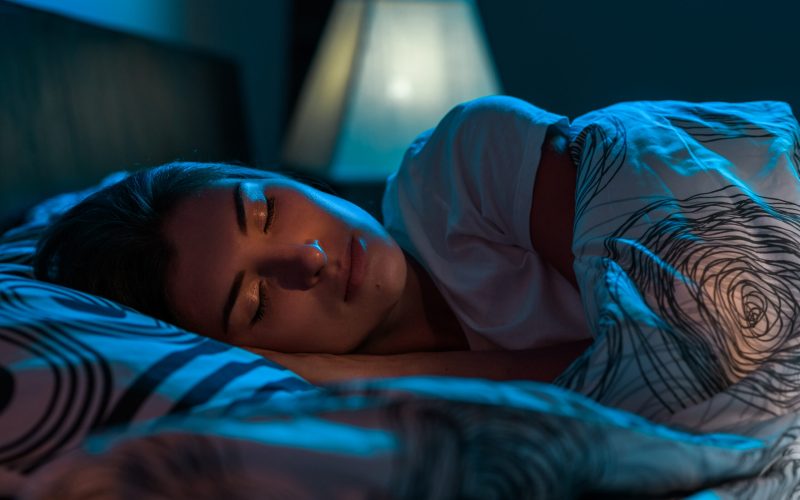 Young attractive Woman sleeping in a bed in a dark bedroom